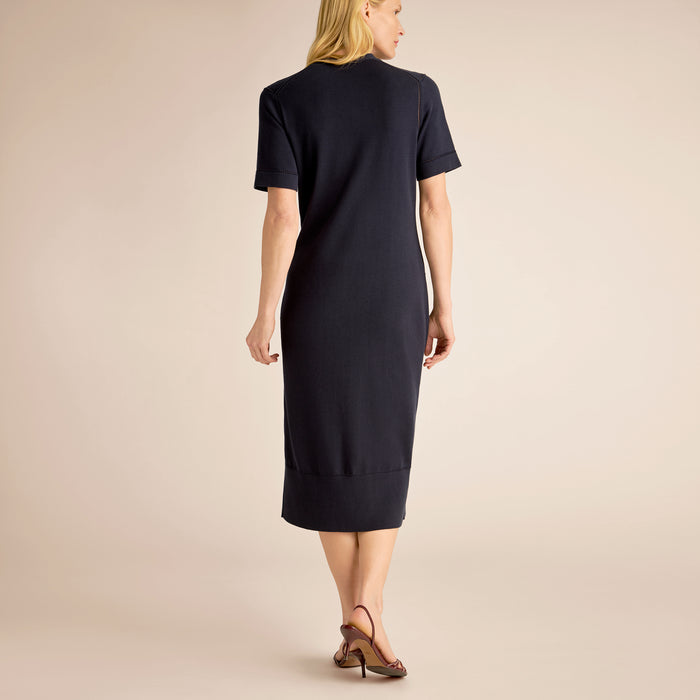 Woman wearing a black dress against a beige background