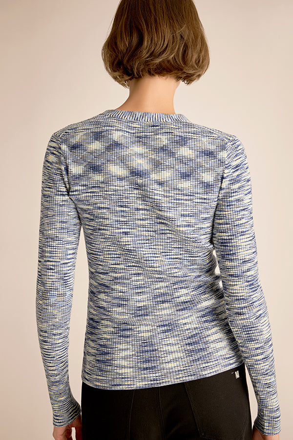 Person wearing a blue and white patterned long-sleeve shirt on a beige background | Exclude