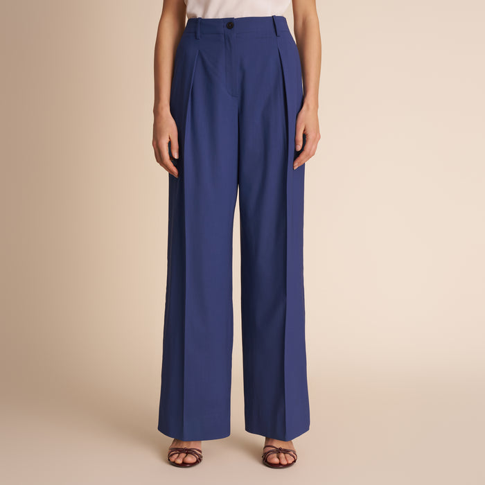 Blue pants worn by a person on a beige background | Lead