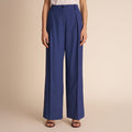 Blue pants worn by a person on a beige background | Lead